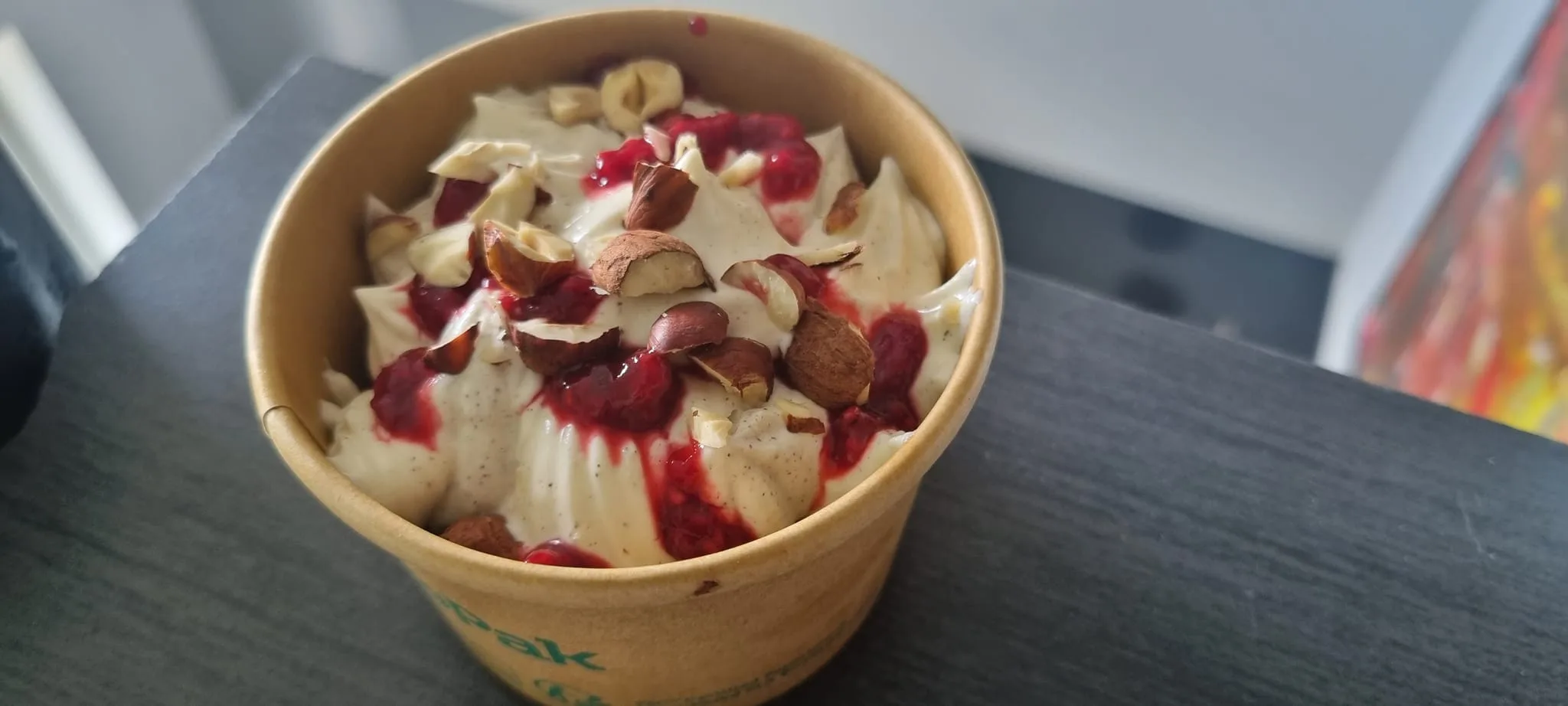 Ice cream topped with nuts and berry sauce.