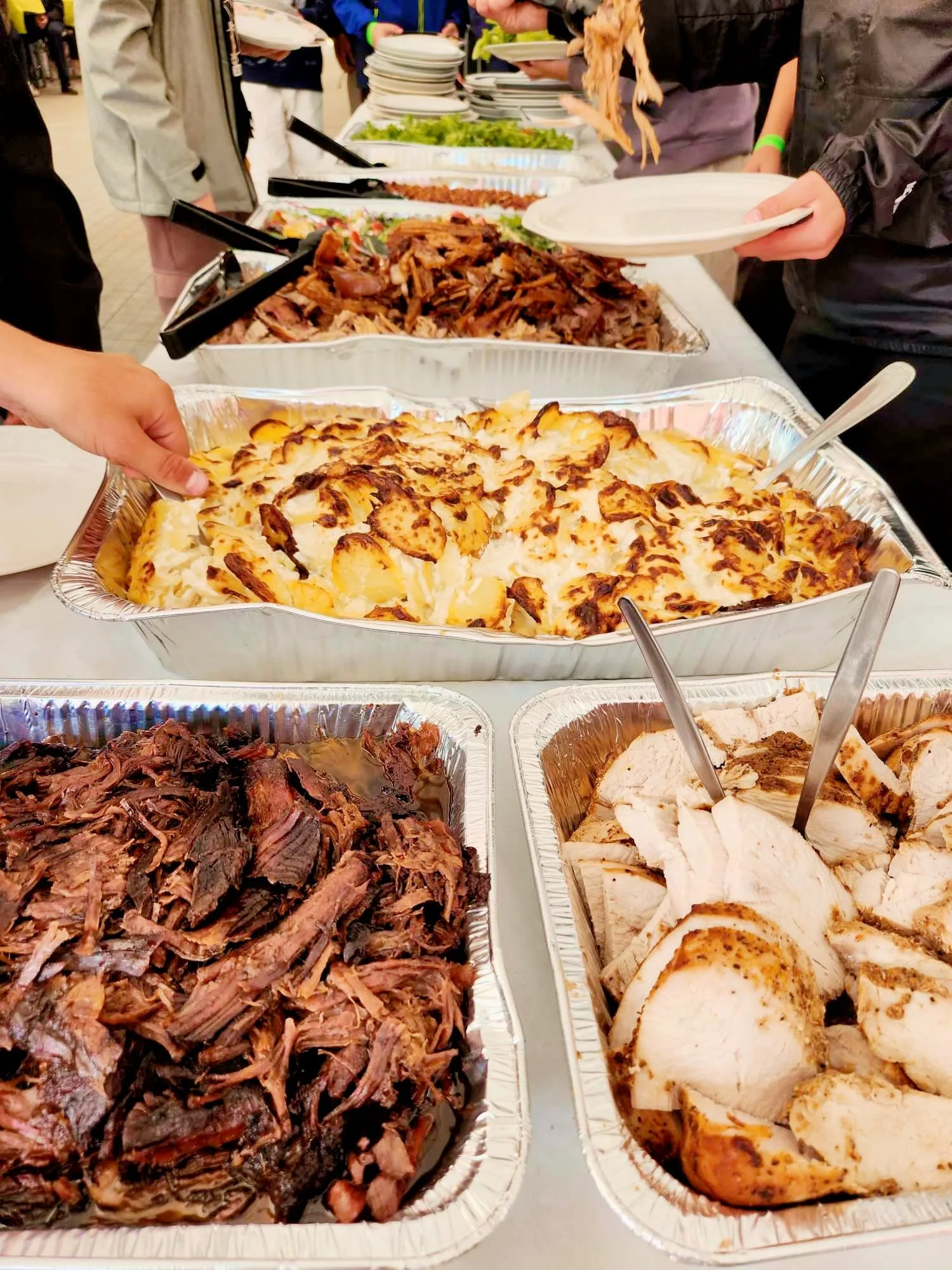 Buffet with roasted meats and cheesy potatoes