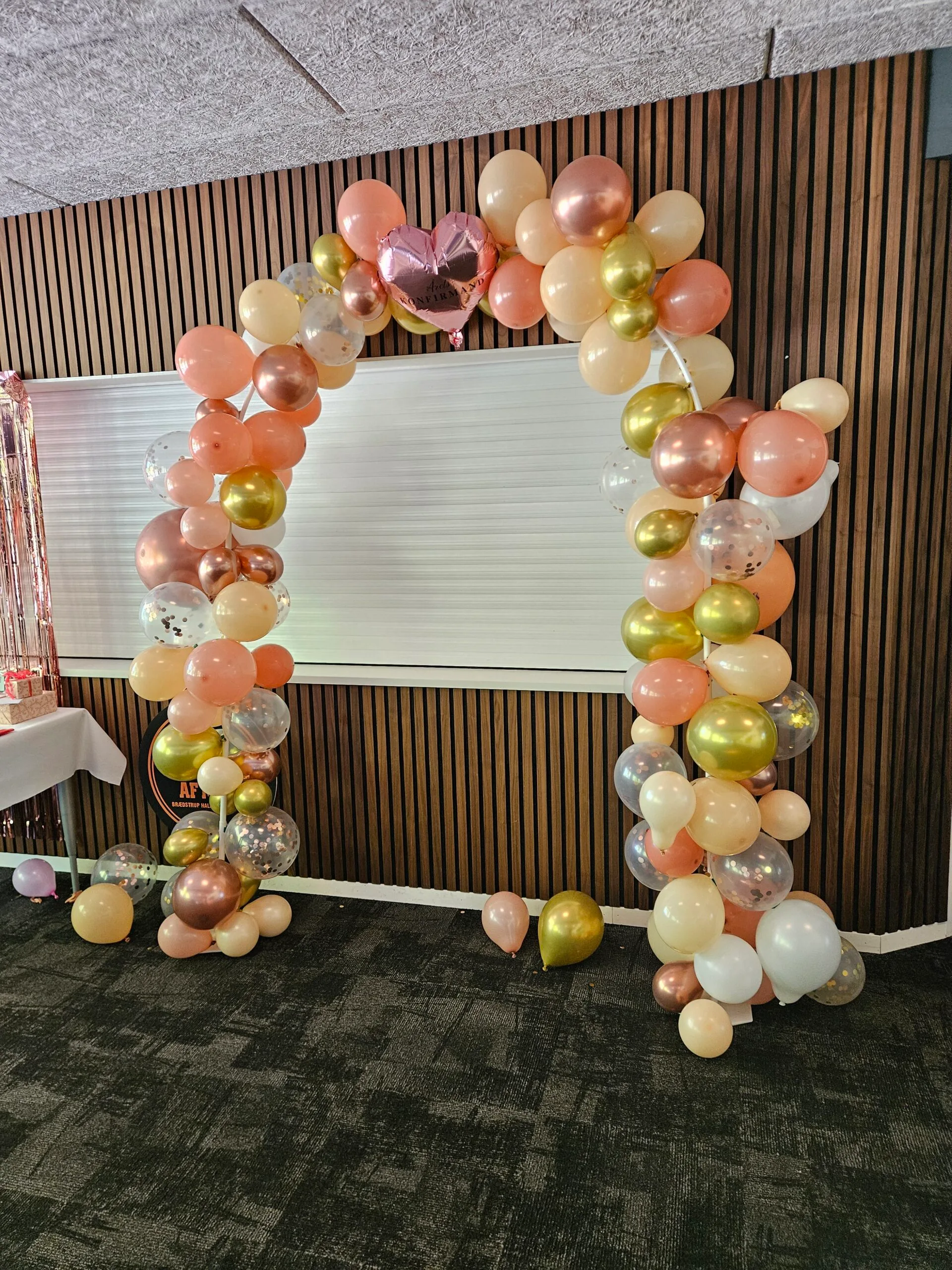 Balloon arch with pink, gold, and white balloons.