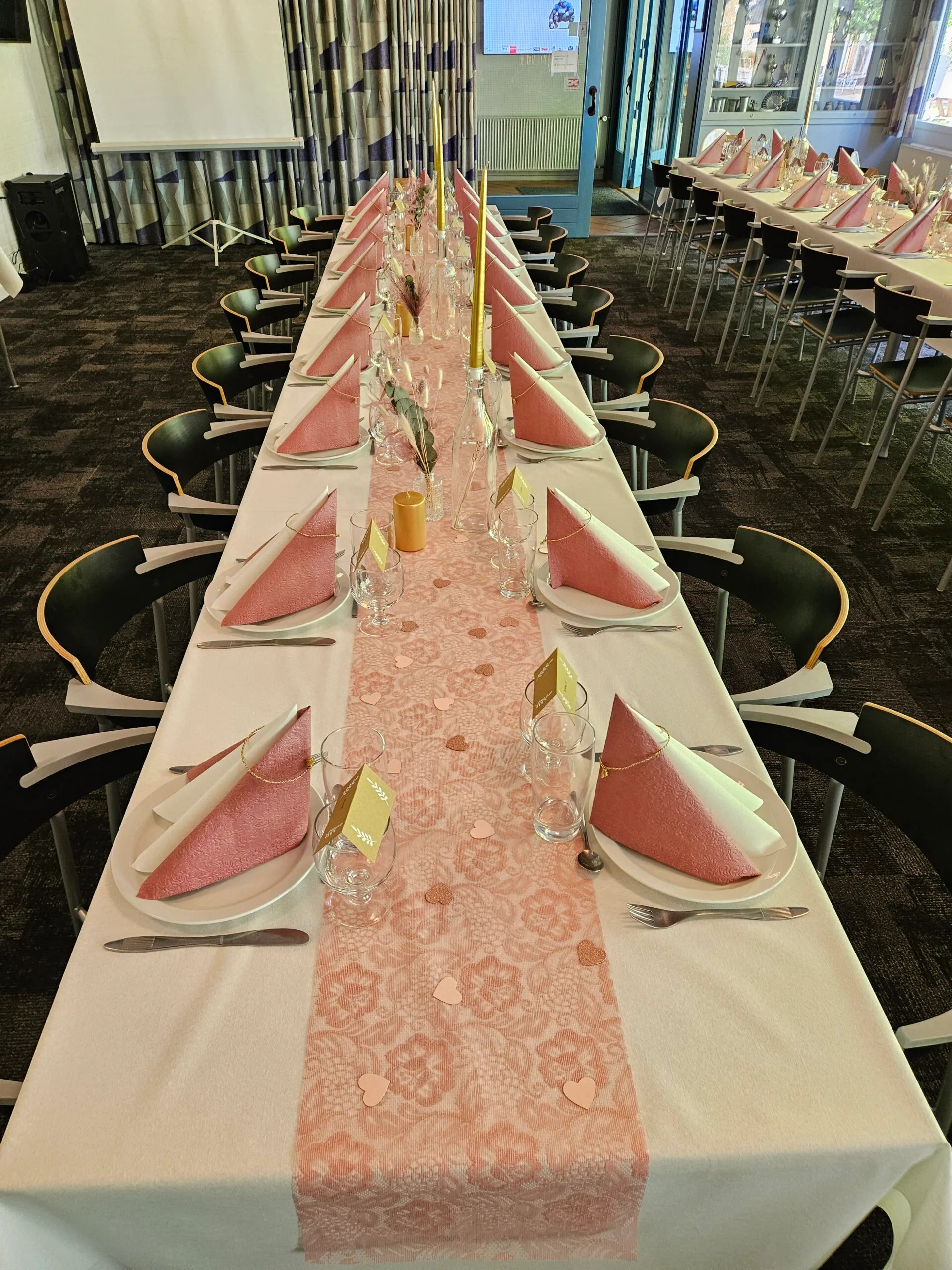 Elegant dining table with pink decorations and napkins.