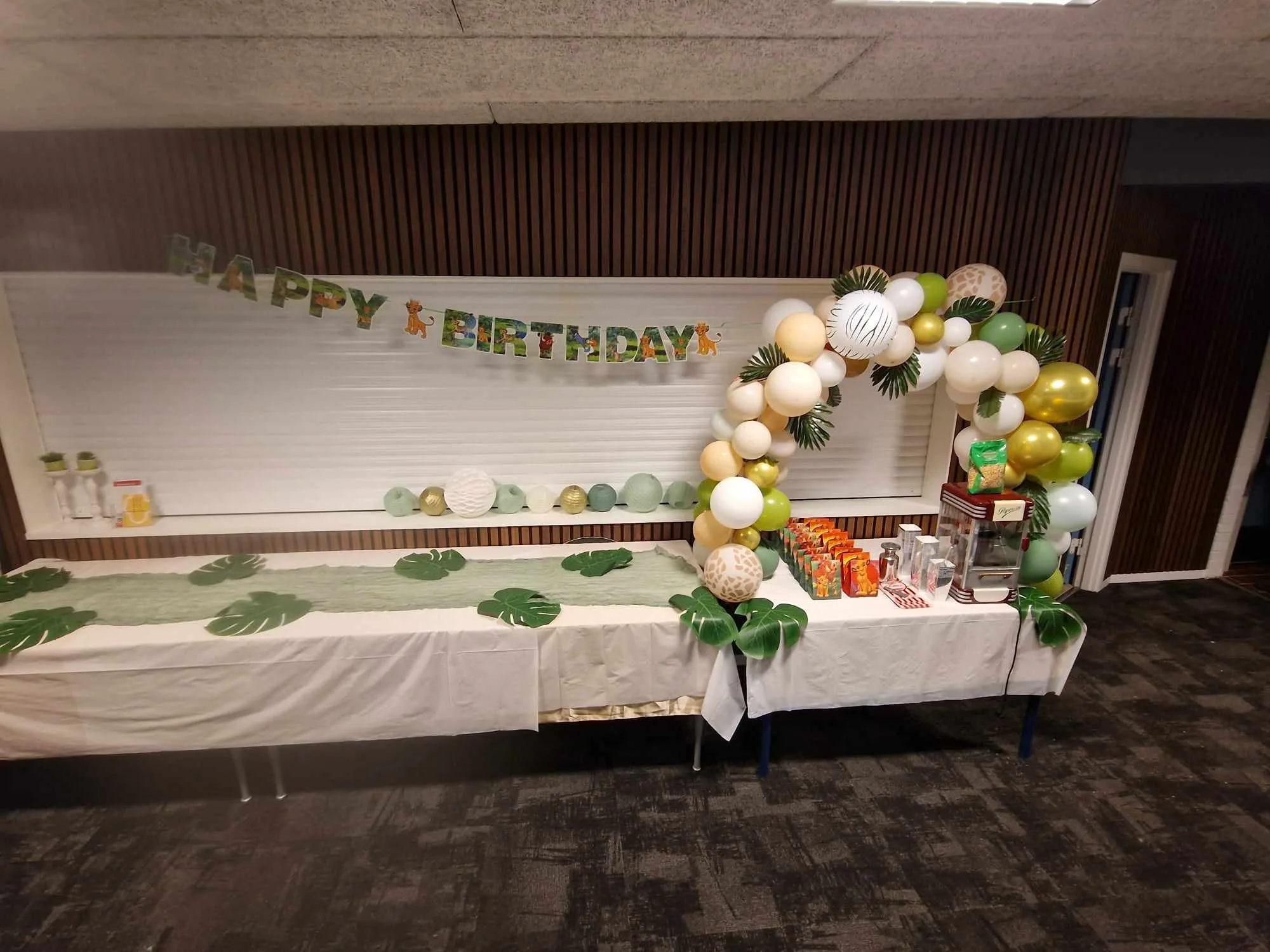 Jungle-themed birthday party decorations with balloons and banner.