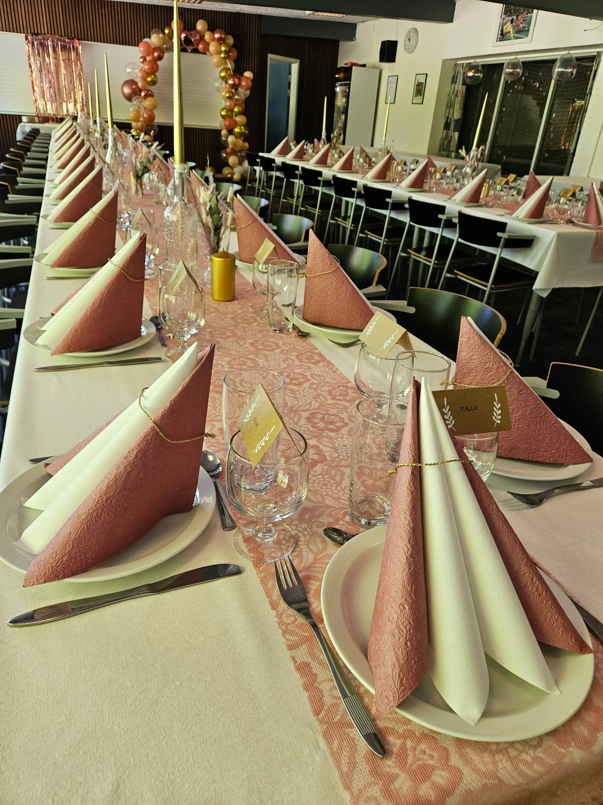 Elegant table setting with pink napkins and decorations.