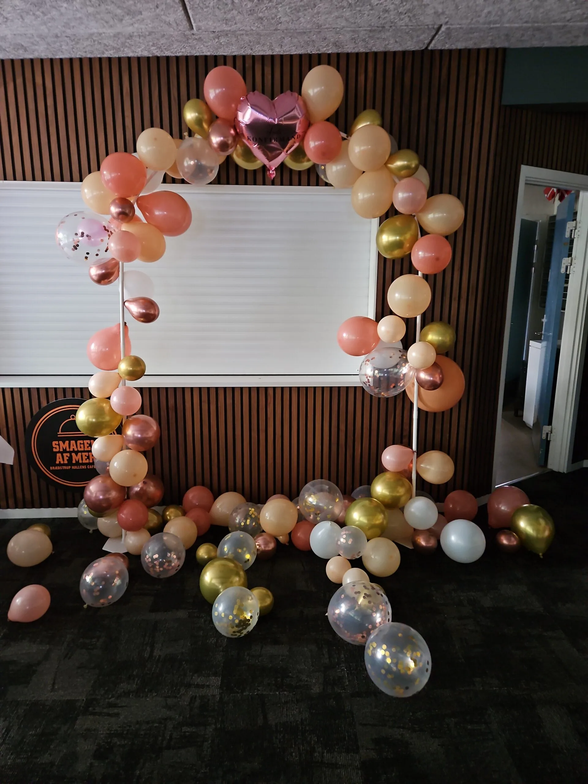 Colorful balloon arch with heart balloon centerpiece.