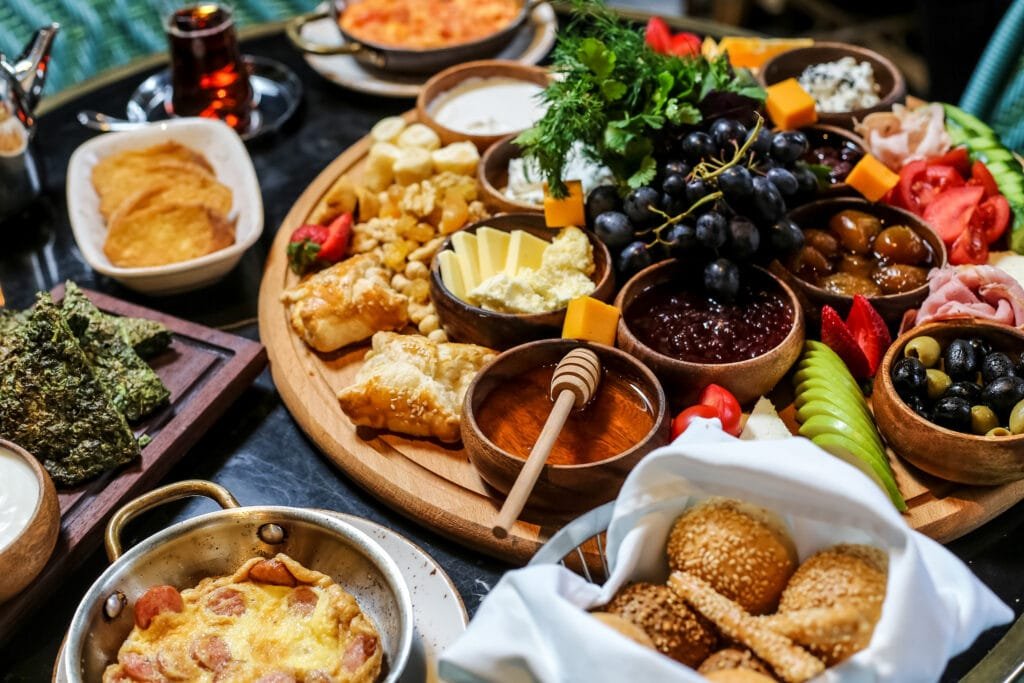 Assorted brunch platter with fruits, cheese, pastries.