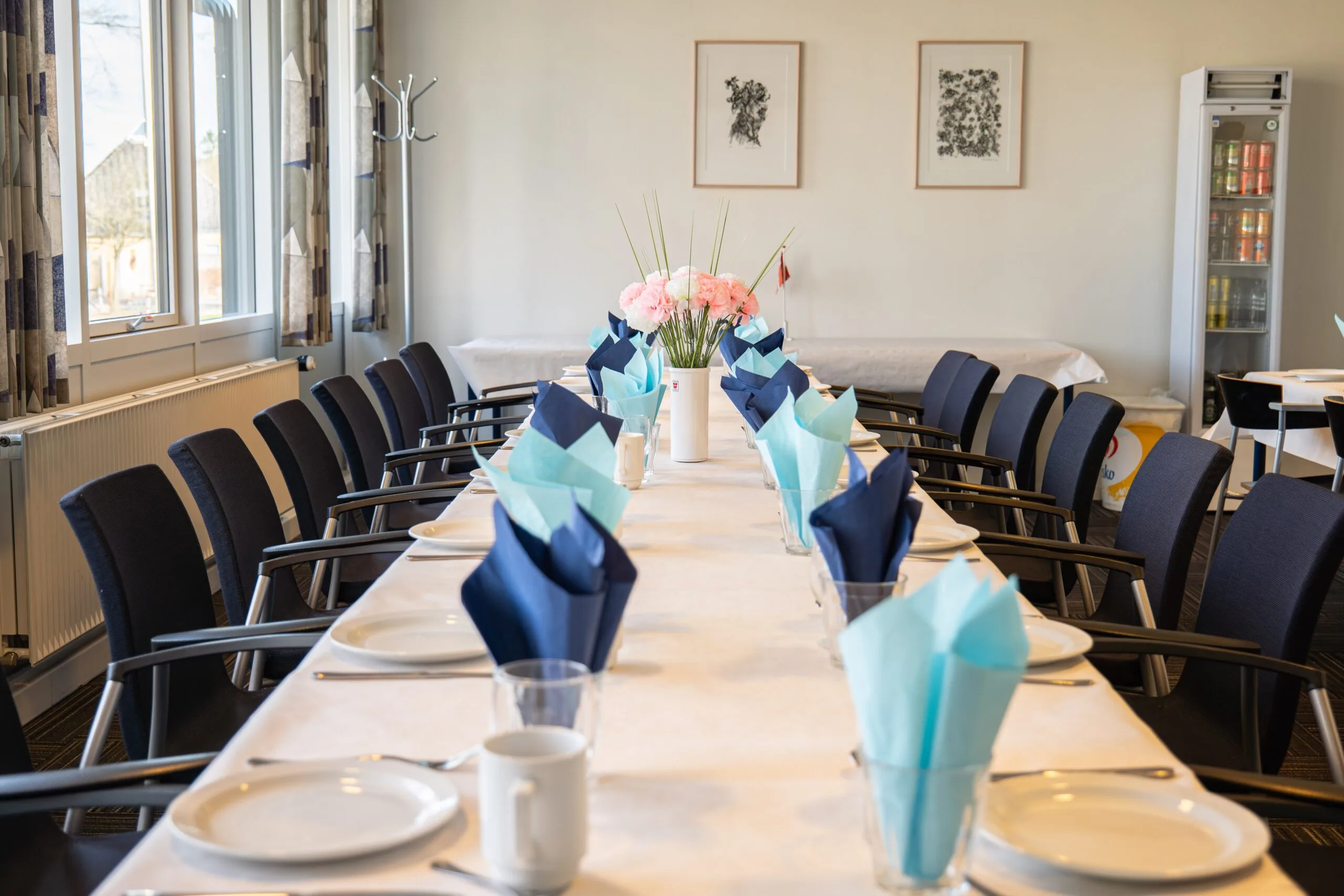 Long dining table set with blue napkins