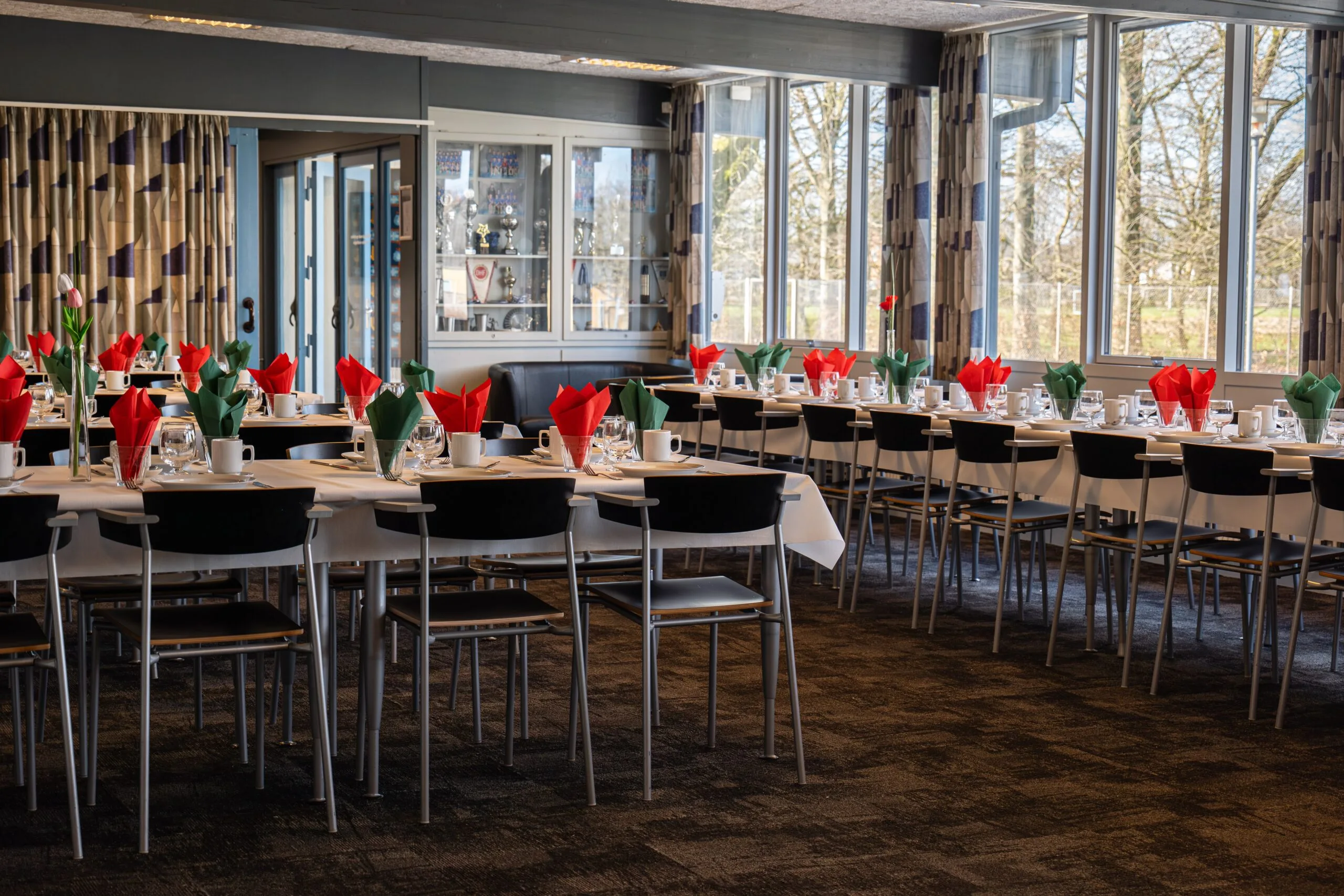 Banquet hall with tables set and red napkins