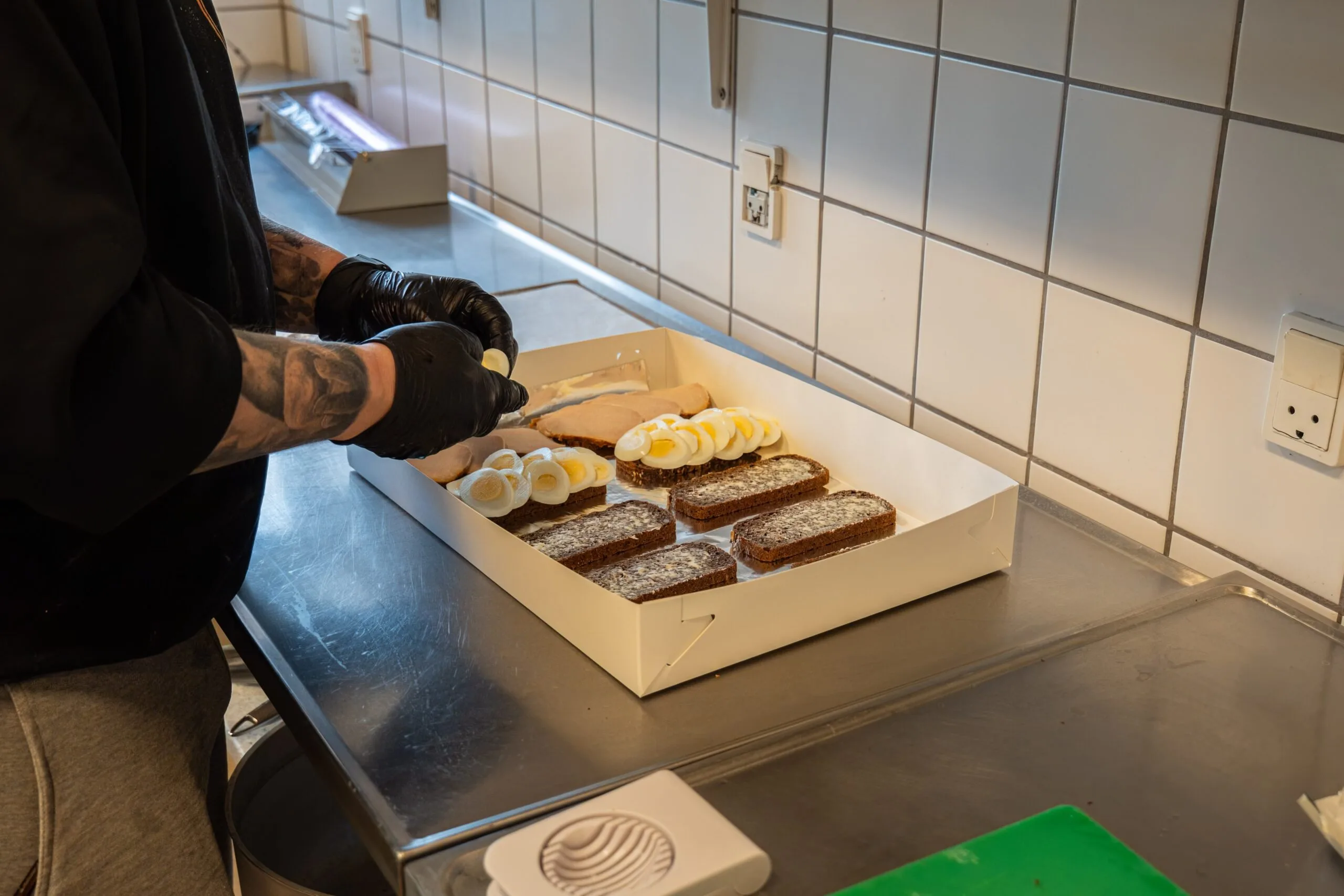 Person preparing open-faced egg sandwiches in kitchen