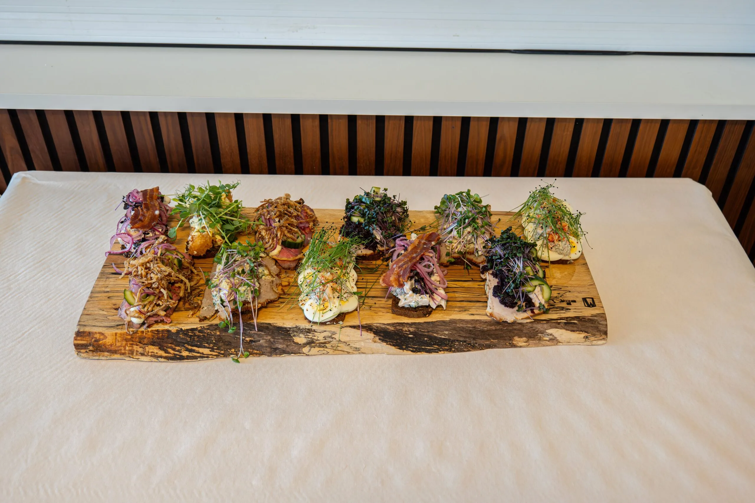 Assorted open-faced sandwiches on rustic wooden board